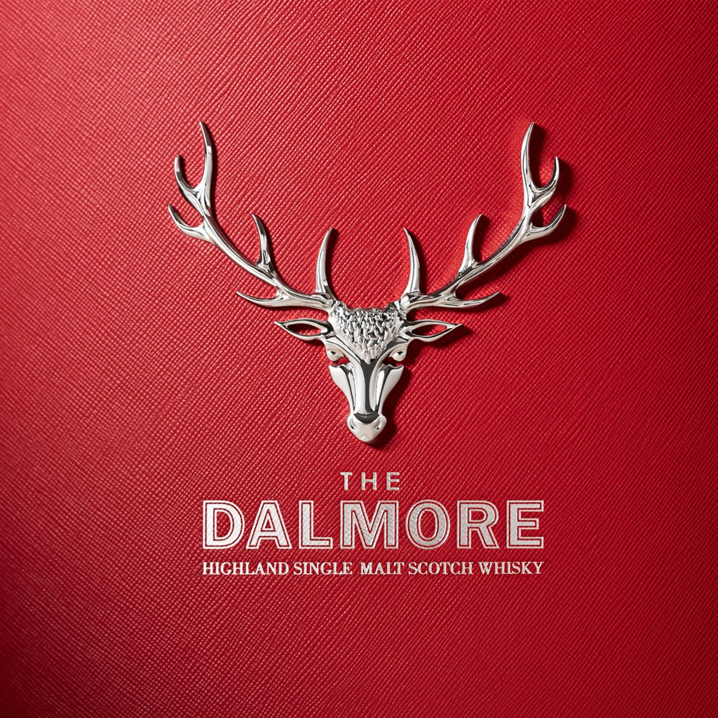 The Dalmore Silver Stags Head Emblem on a deep red background with the text The Dalmore Highland Single Malt Scotch Whisky