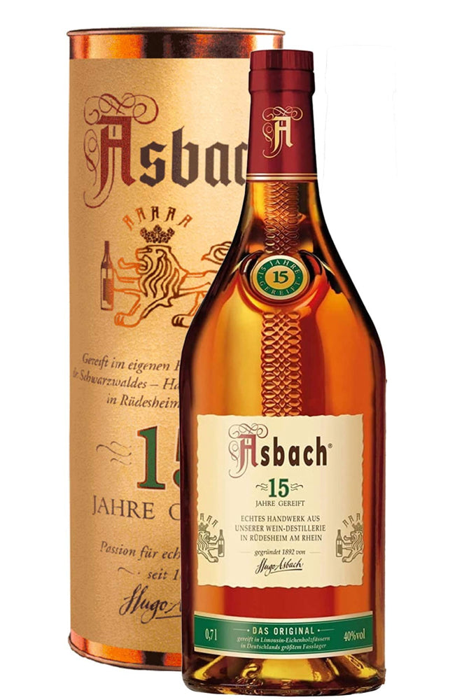 A bottle of Asbach 15 Jahre Original Schwarzwasser next to its tall cylindrical cardboard packaging tube, both featuring the brand's lion logo and golden-brown tones, set against a plain white background.