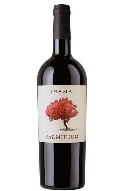 A bottle of Inama Carminium red wine with a black glass body, black foil neck, and a cream-colored label featuring a red tree illustration.