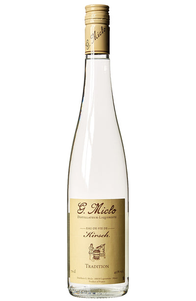 A clear glass bottle of Micolo Kirsch Tradition Eau de Vie spirit, featuring a cream screw cap neck wrap and a cream label with black text, set against a plain white background.