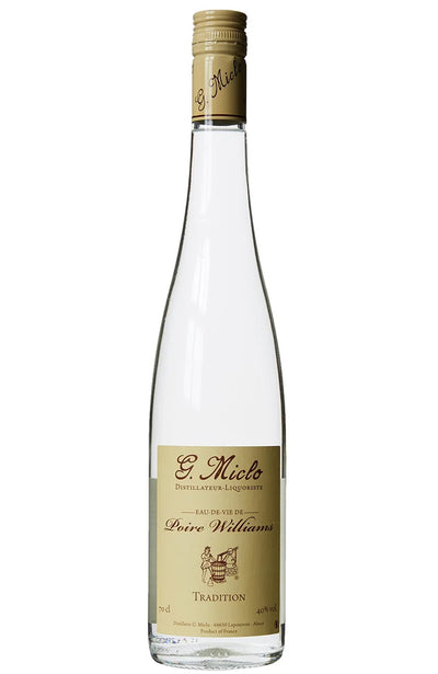 A clear glass bottle of G. Miclo Poire Williams Tradition Eau de Vie, featuring a cream screw cap and a cream label with black text, set against a plain white background.