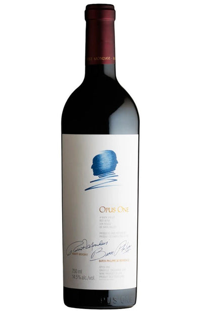 A bottle of Opus One red wine with a white label featuring a blue stylized head graphic and gold lettering, set against a plain white background.