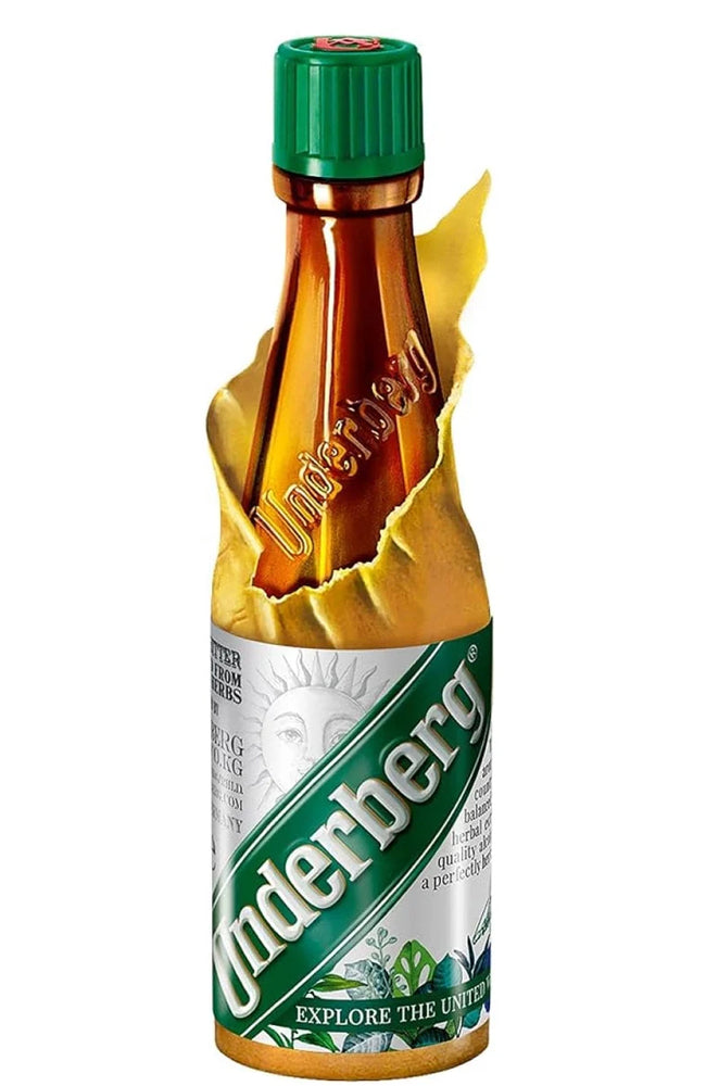 A miniature glass bottle of Underberg wine with a green cap, shown on a white background with a yellow graphic effect tearing back the label.