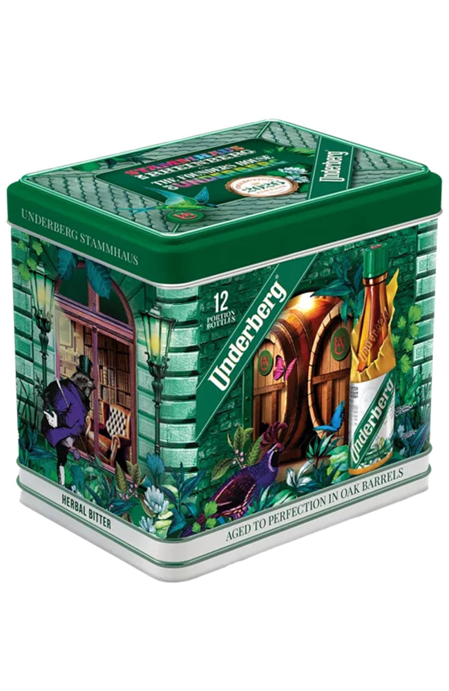 A green and white decorative metal tin of Underberg Bitters, featuring illustrated scenes of a bookstore and an oak barrel on a white background.