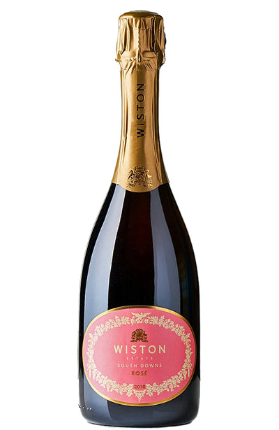 A bottle of Wiston Estate South Downs Vintage Rosé sparkling wine, featuring a dark glass bottle with a gold foil capsule and a pink oval label.